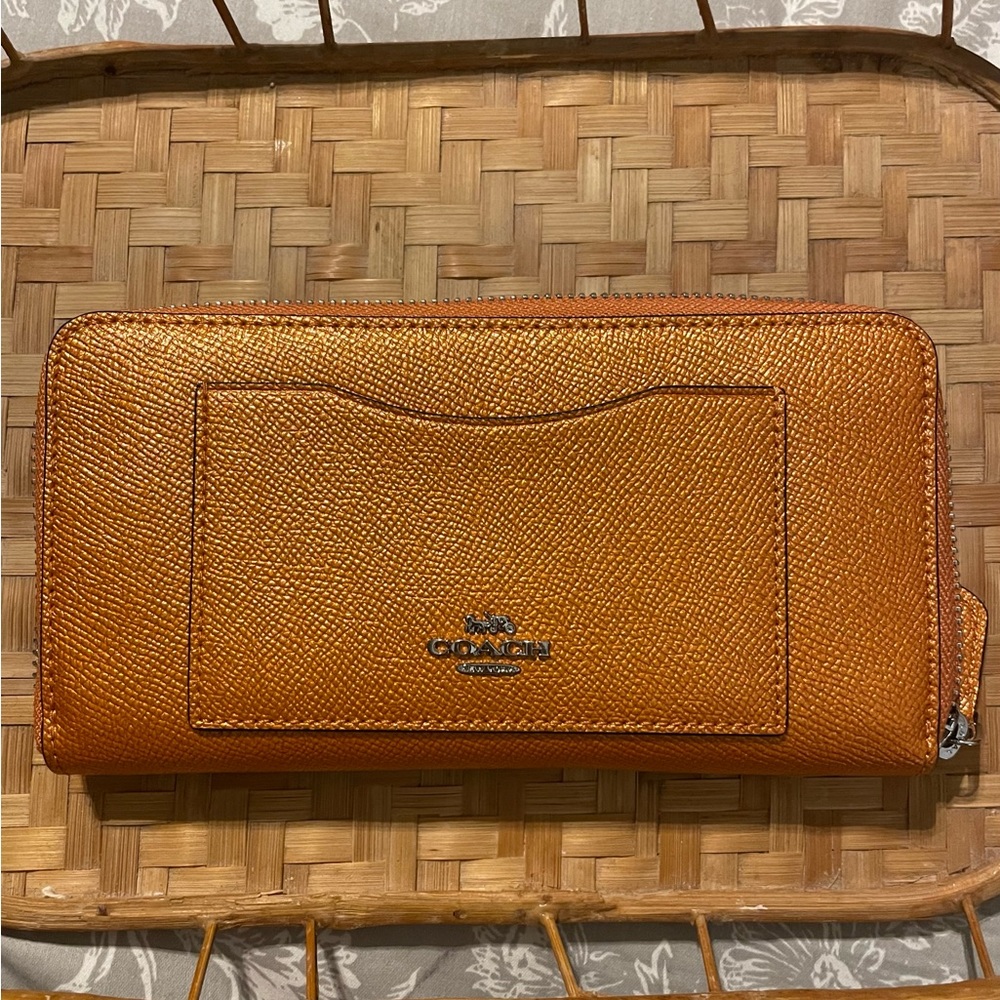 NWT, Coach tangerine metallic zip-around wallet. 4”x7.5”. No flaws or issues.